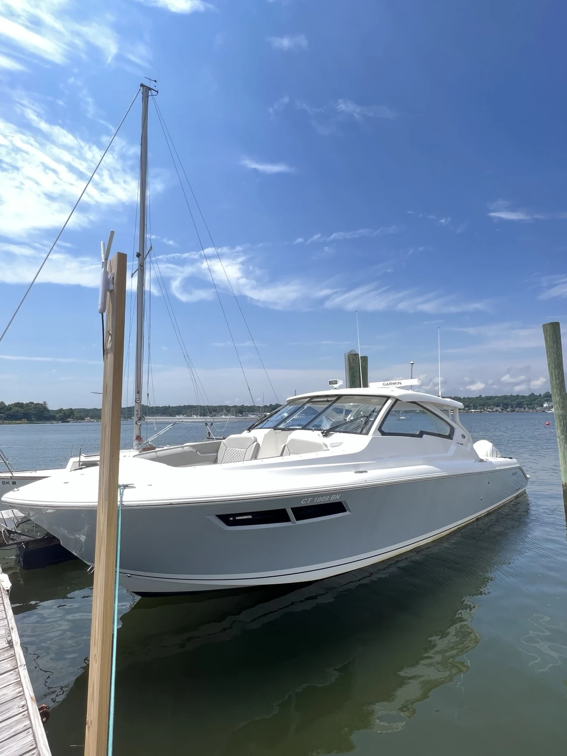 Large gray bowrider and day boat at the marina