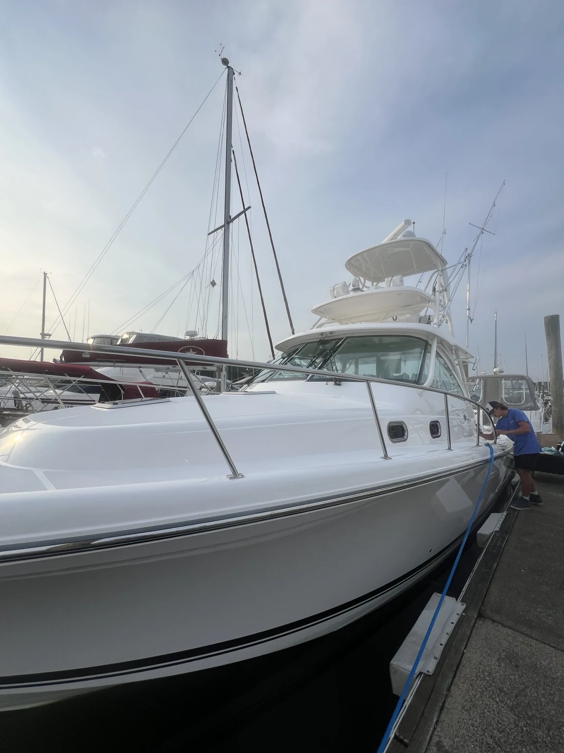Superior Marine actively detailing the starboard side of a large white sportfishing boat